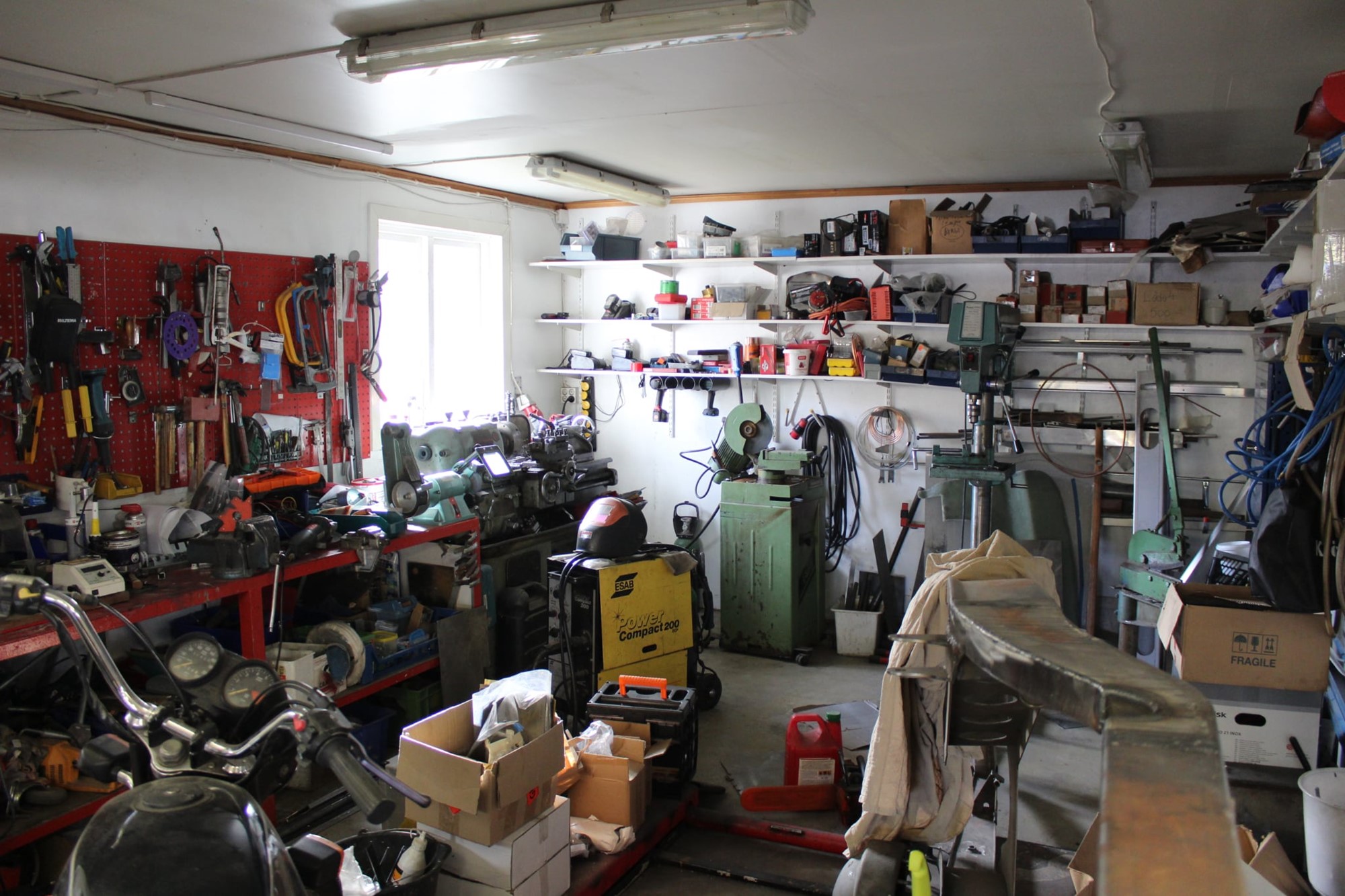 Det är lita av ett gammalt hotrod garage hemma hos Kvarnberg verktyg överallt en svarv, en kapmaskin en svets och mitt i alltihop står en 32a ram bredvid en motorcykel.
