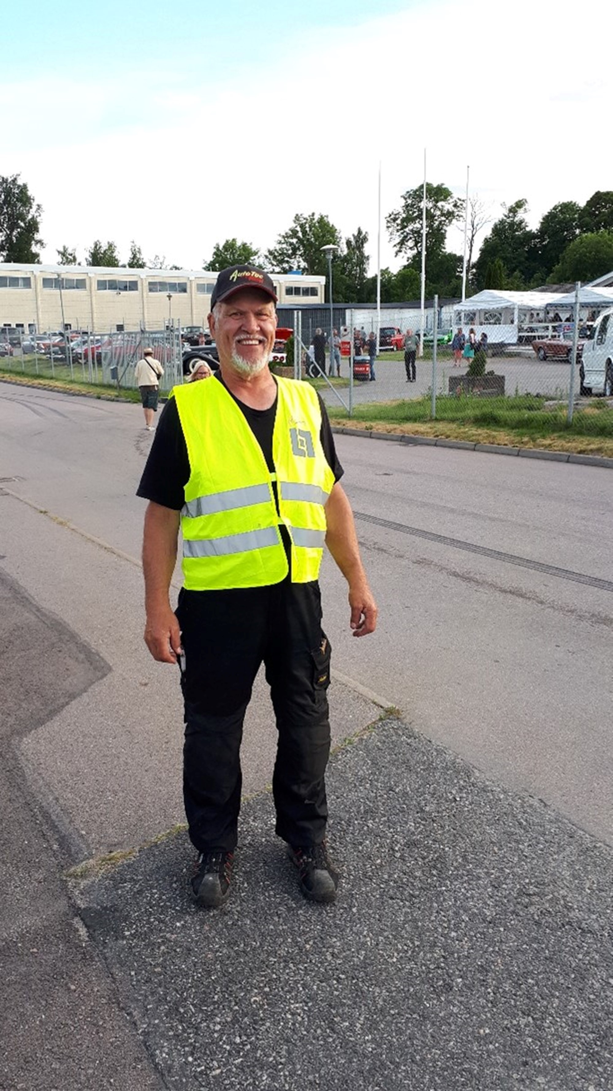 Pappa Peter agerar trafikdirigent på parkeringen när det är Summer Meet